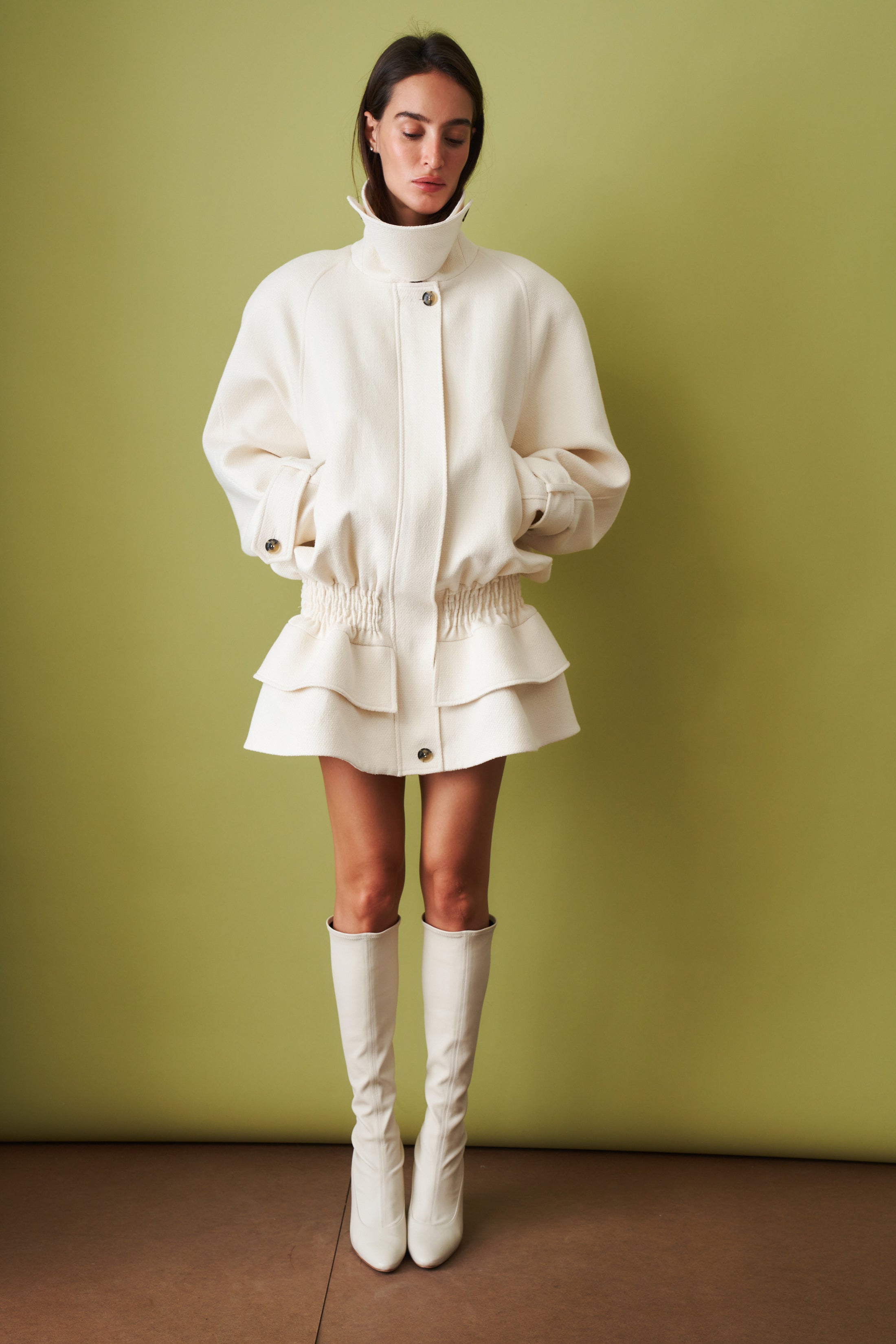 Ecru coat by THE MANNEI, stylish jacket with tailored fit and classic design, displayed on a hanger.