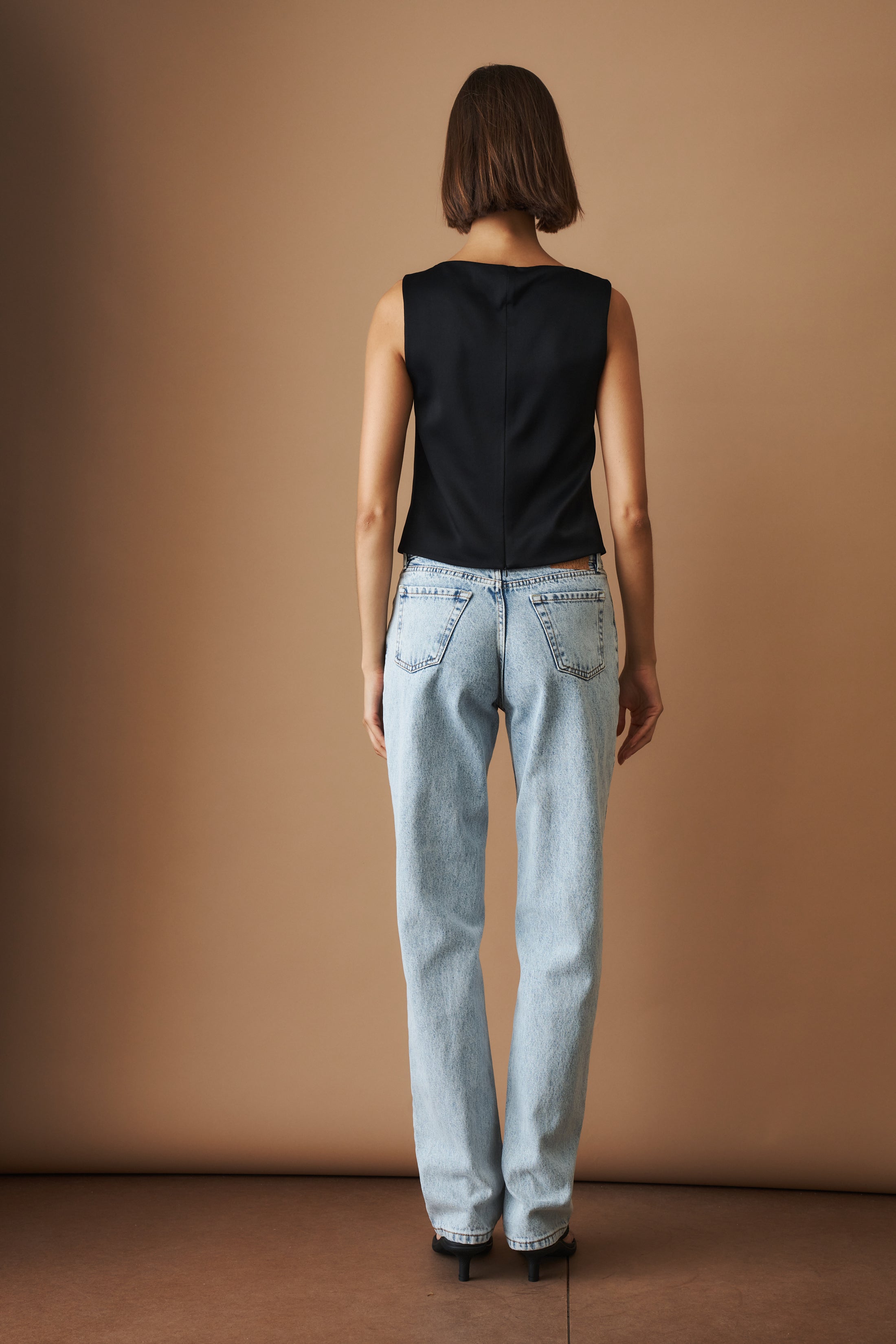 DÉSORDRE Hargrave top in neutral fabric with long sleeves and relaxed fit, displayed on a hanger against a plain background.