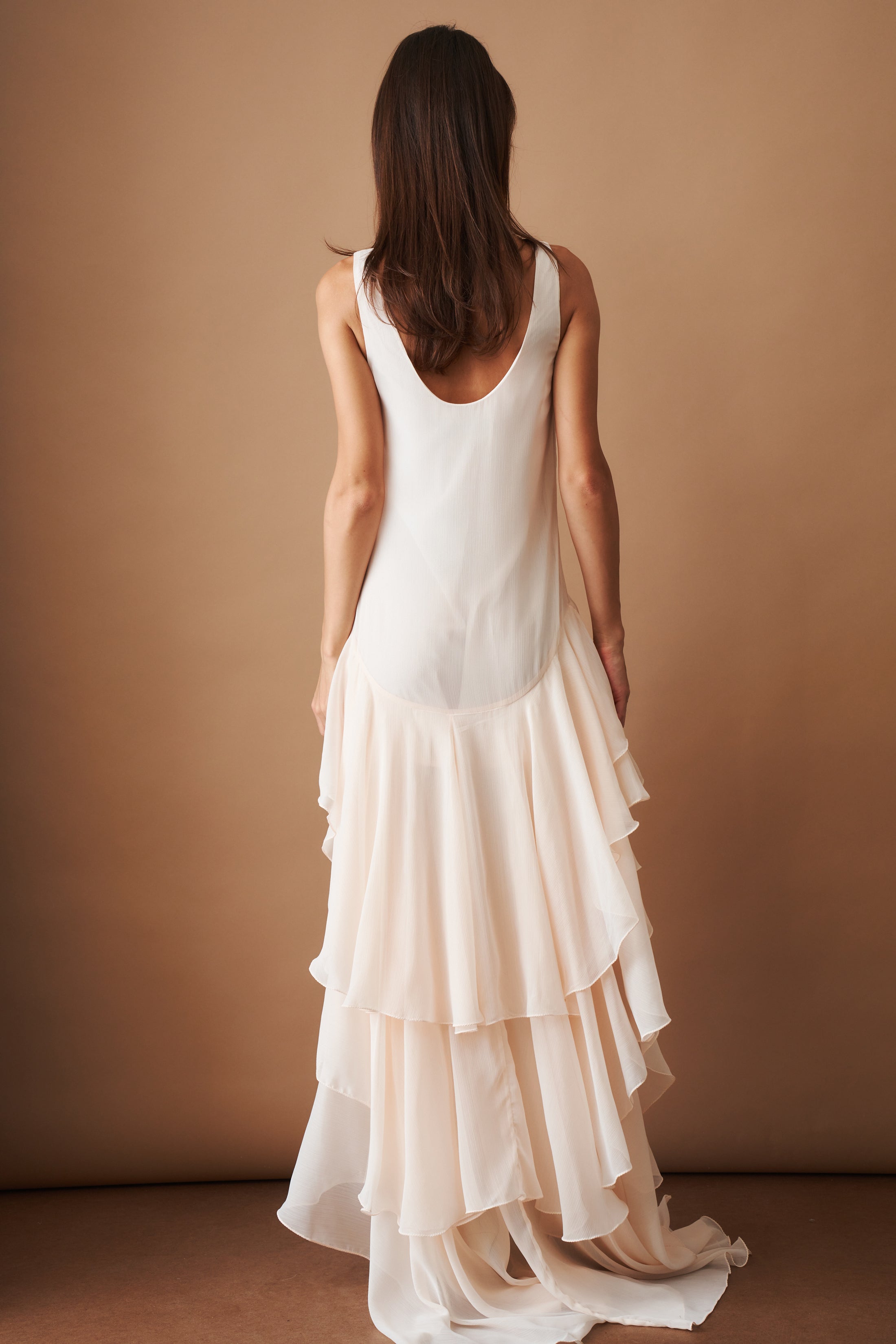 Light pink chiffon ruffle dress by ROTATE, featuring flowing fabric and layered ruffles for a stylish, elegant look.