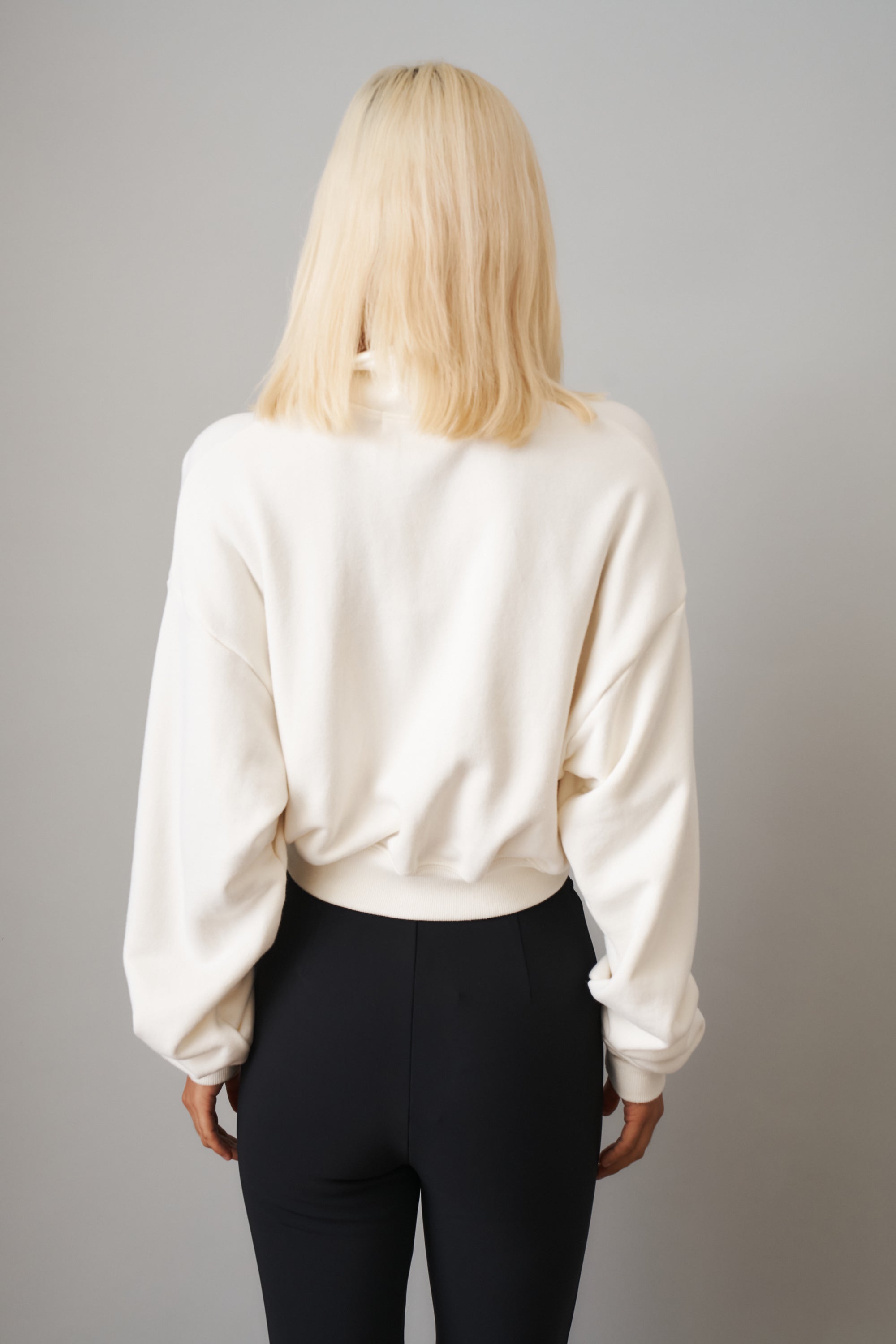Cream cropped half-zip sweatshirt by ETERNE, showcasing a fitted tops style with a zip-up collar and long sleeves.