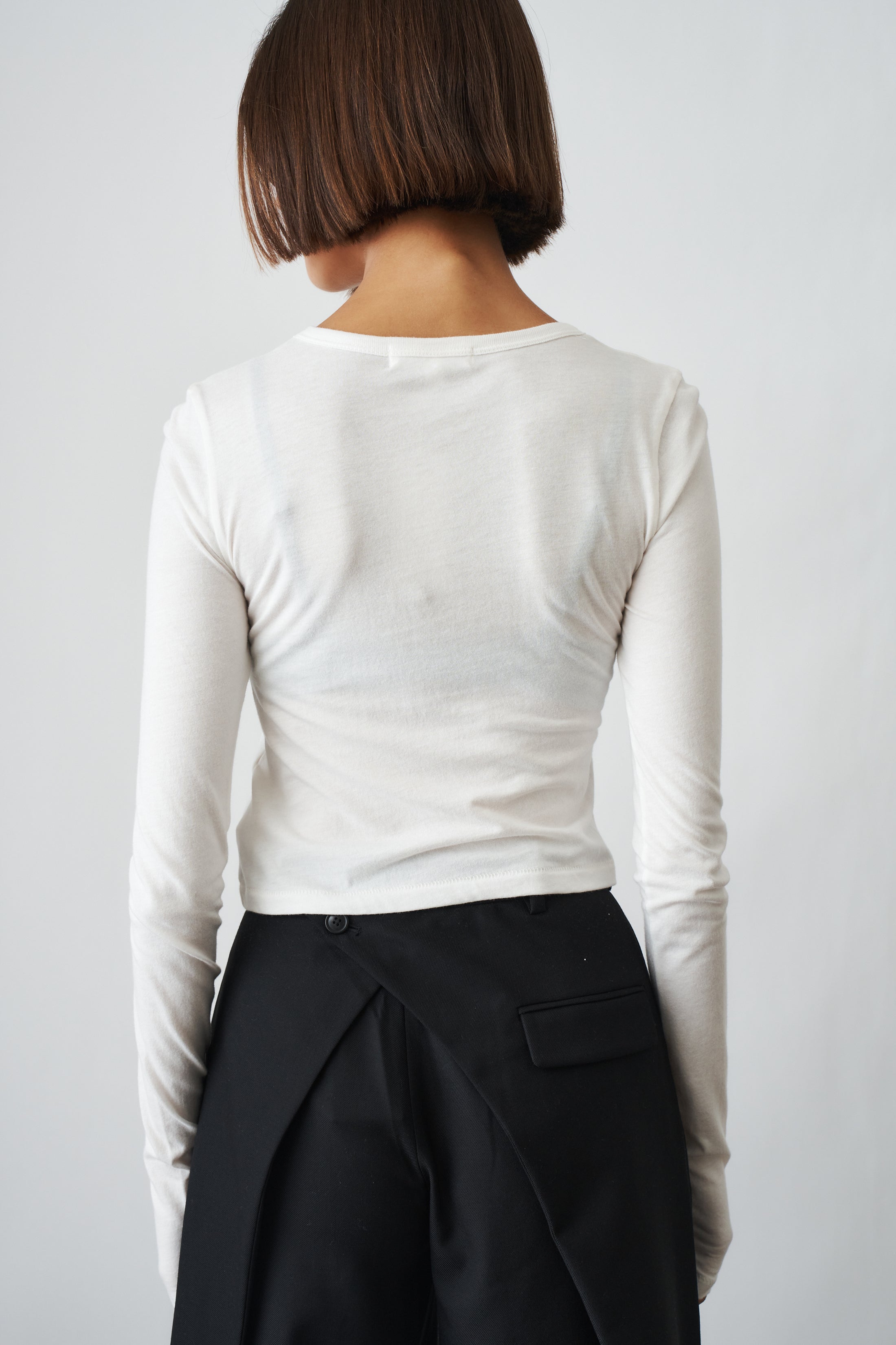 Ivory long sleeve baby tee by ETERNE, soft cotton top for infants featuring a simple, comfortable design.