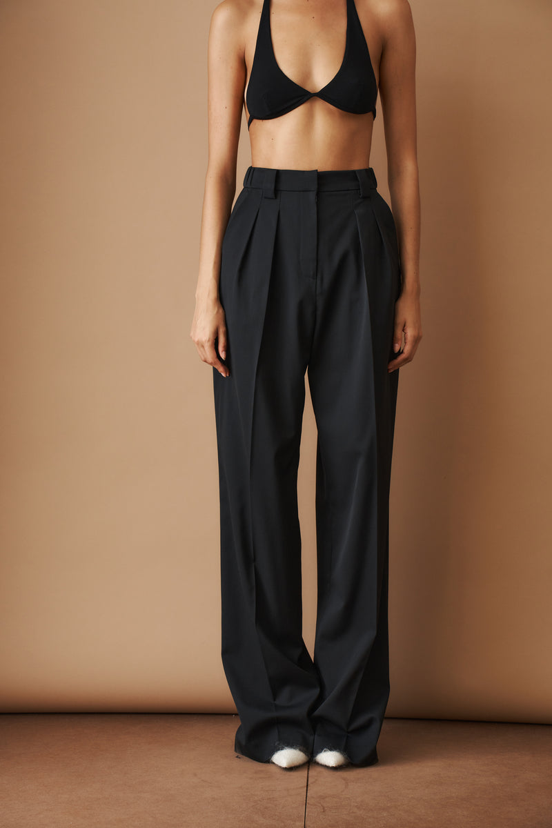 Black wool pants from MOMS PANTS, featuring a comfortable fit, shown on a model with a relaxed, stylish look.