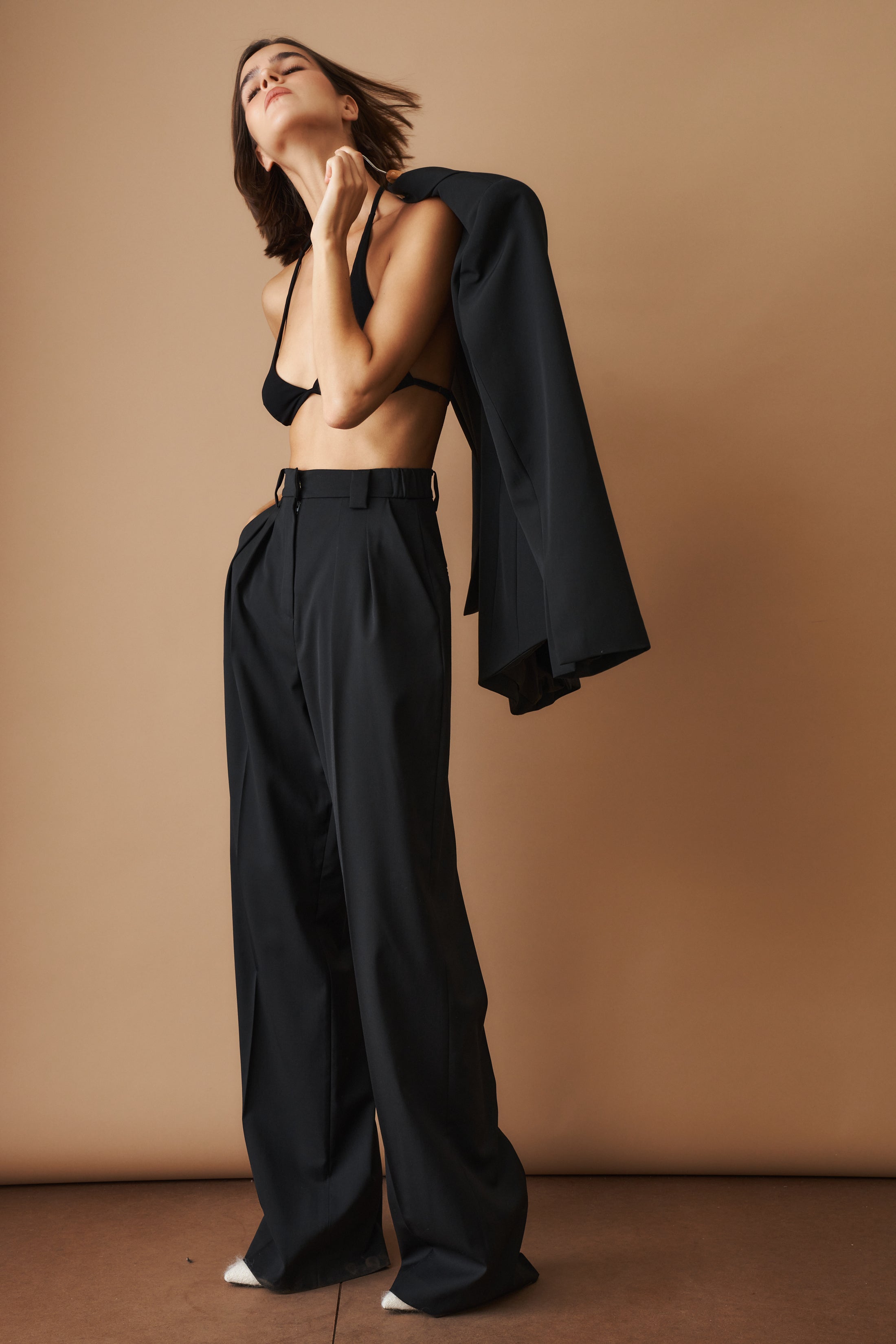 Black wool pants by MOMS PANTS, featuring a tailored fit and smooth fabric, shown in a close-up view.