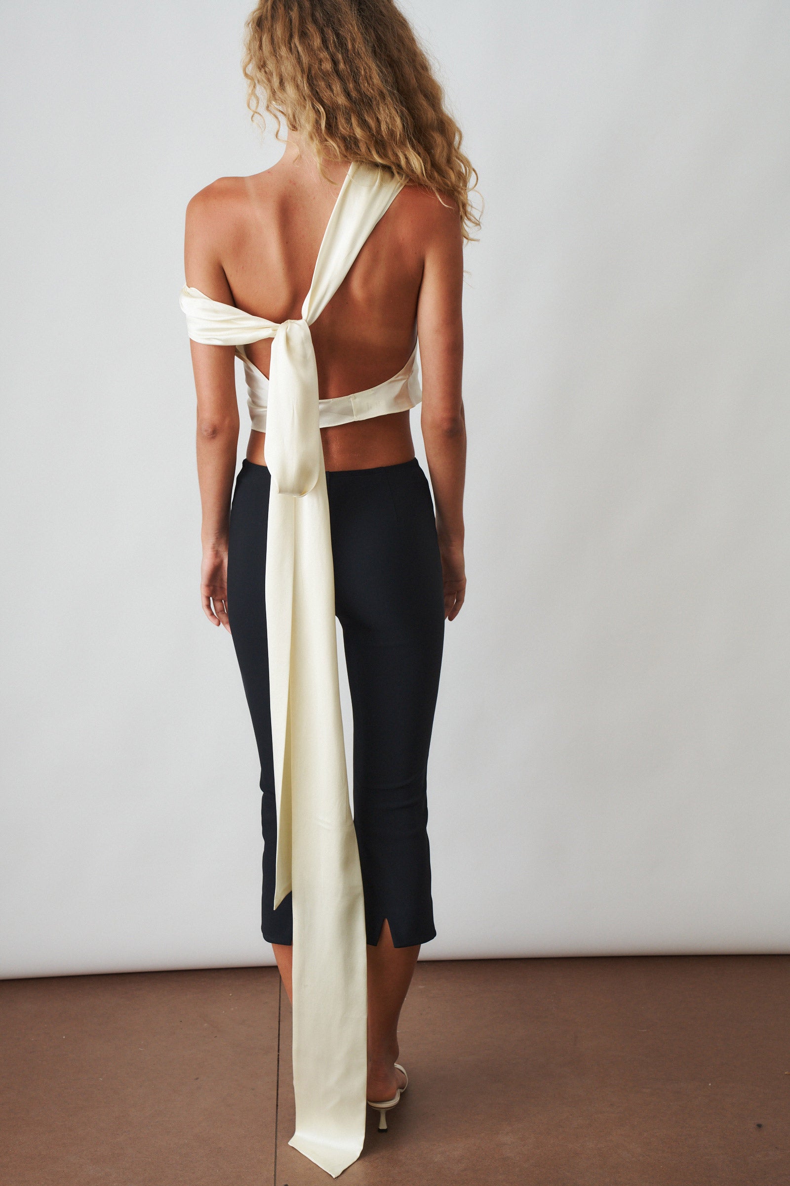 Ivory cowl neck halter top by ORSEUND IRIS, featuring a stylish draped neckline and sleeveless design.