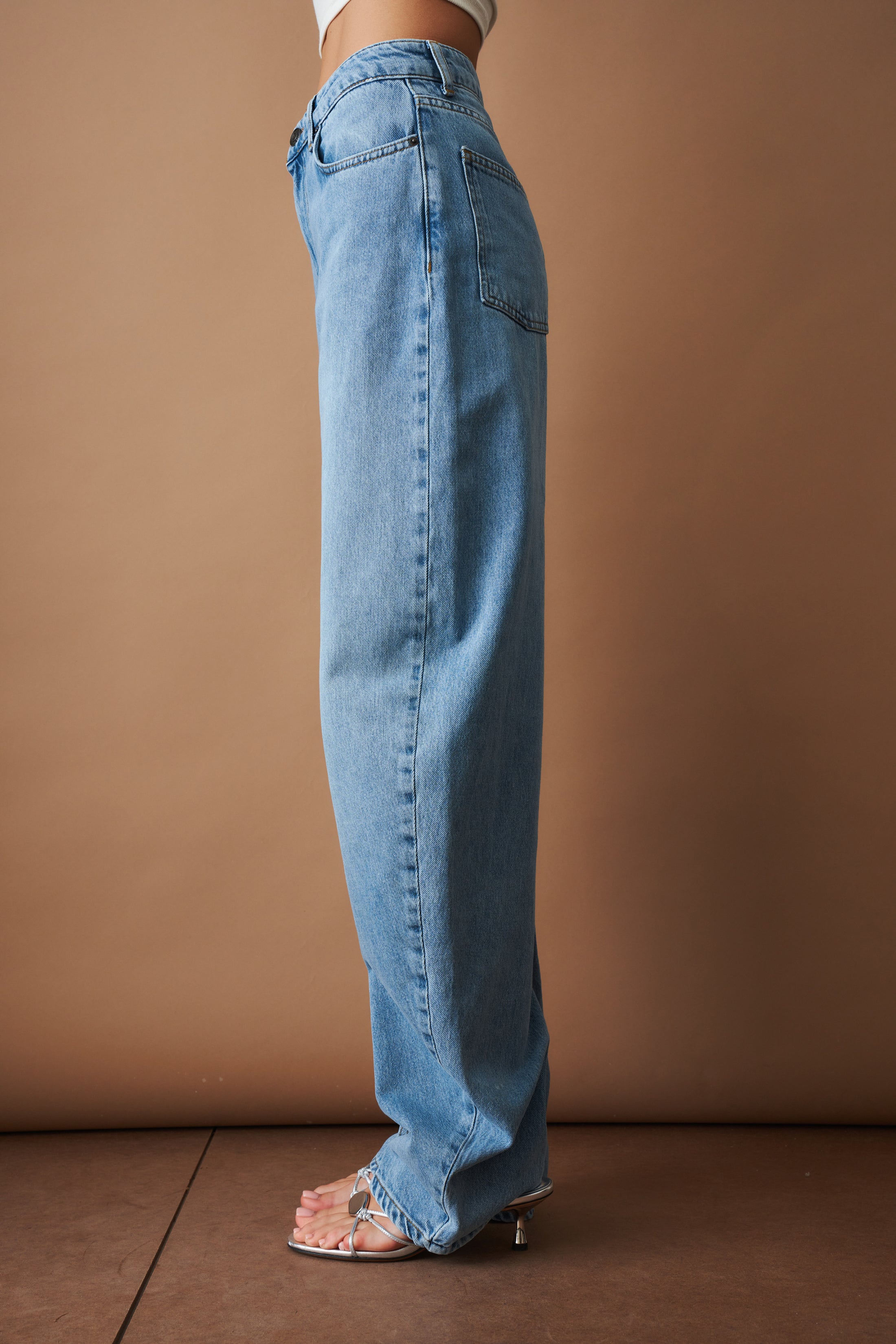 Rotate Draped Barrel Leg Jeans, stylish denim pants with draped design and barrel legs, displayed on a model.
